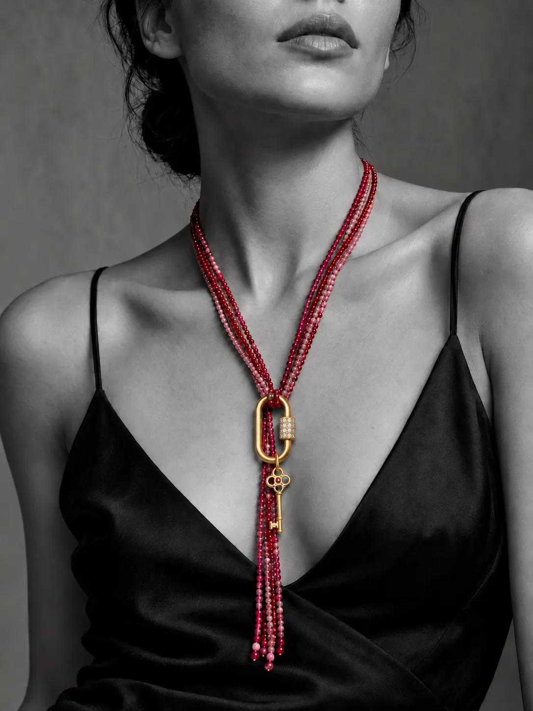 Ruby and pink strands worn long at the front, gathered through a gold pavé carabiner with a small skeleton key charm